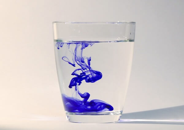 Blue dye dropped in a glass of water